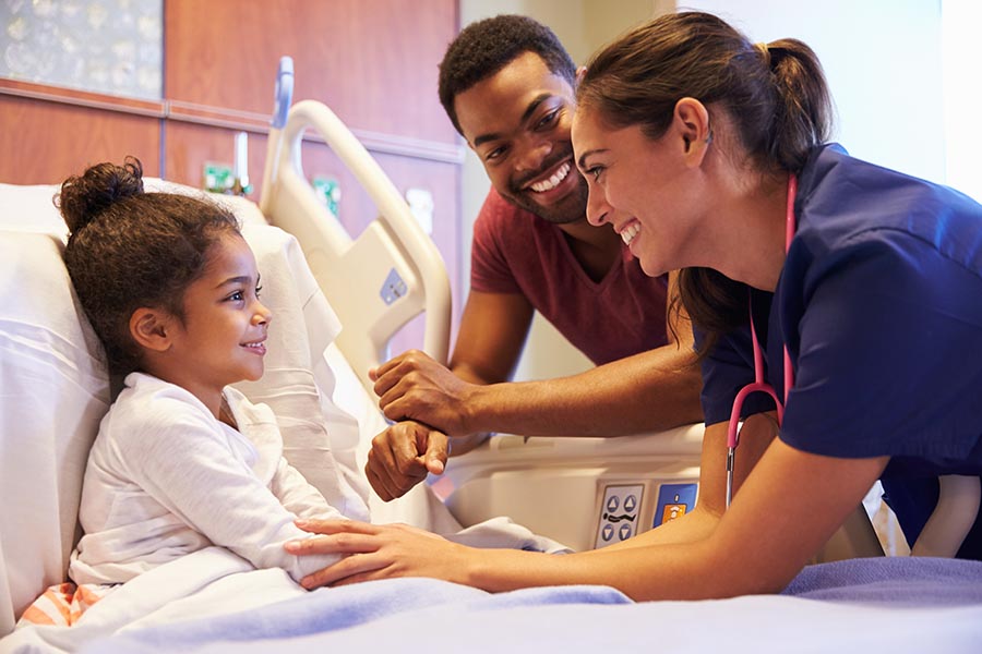 Life and Health Insurance - Nurse Makes a Little Girl in a Hospital Bed Laugh, While Her Father Smiles Nearby