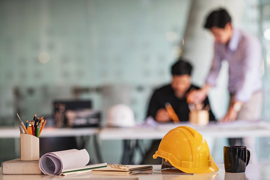 Specialized Business Insurance - Hard Hat and Drafting Tools in a Contractor’s Office